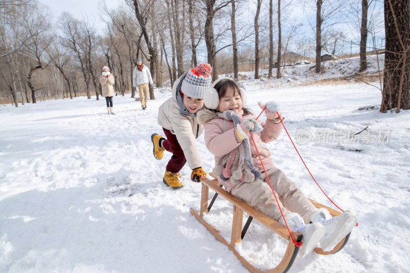 欢乐家庭在雪地上玩雪橇