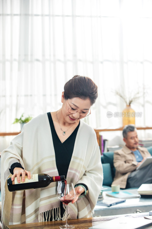 优雅的中老年女士倒红葡萄酒