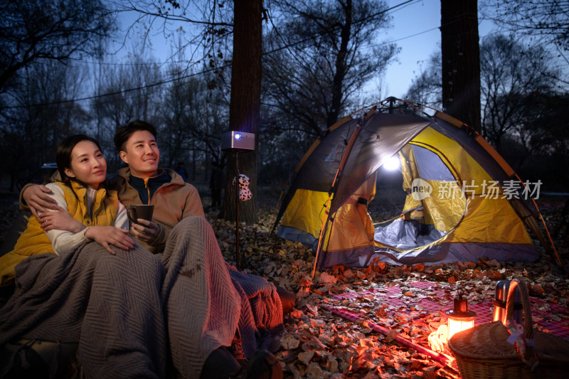 幸福的夫妇夜晚在野外露营