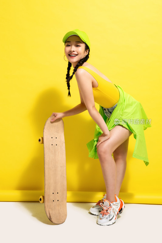 扶着滑板的年轻女孩