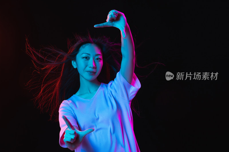 年轻女性霓虹光线下手势动作