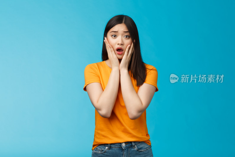 穿黄衣女子双手托脸显惊讶