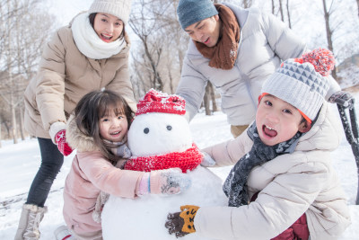 欢乐家庭在雪地里堆雪人