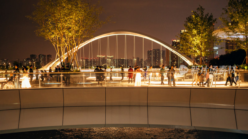 成都交子公园跨越锦江的莲叶景观桥夜晚市民