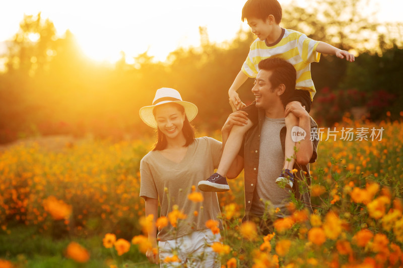 幸福的一家三口站在花丛中