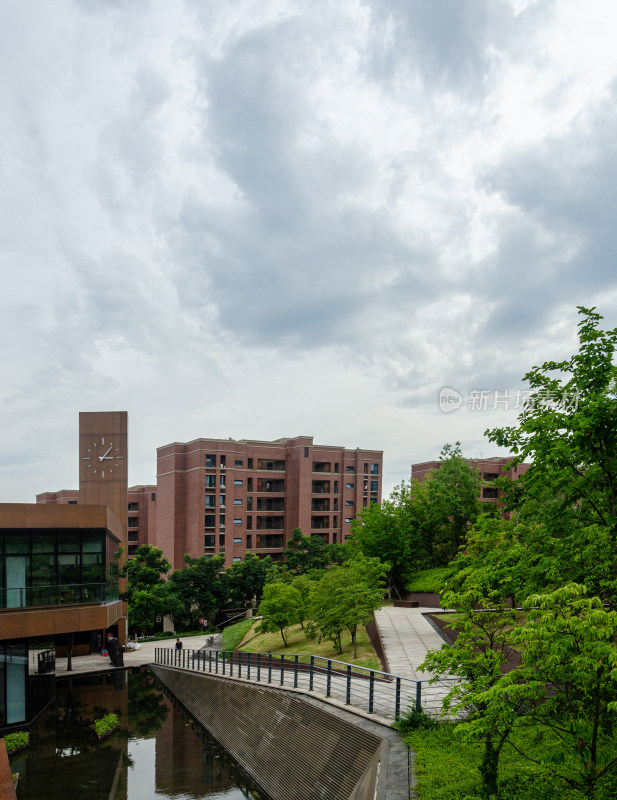 绿树环绕的红砖建筑与水道的景致