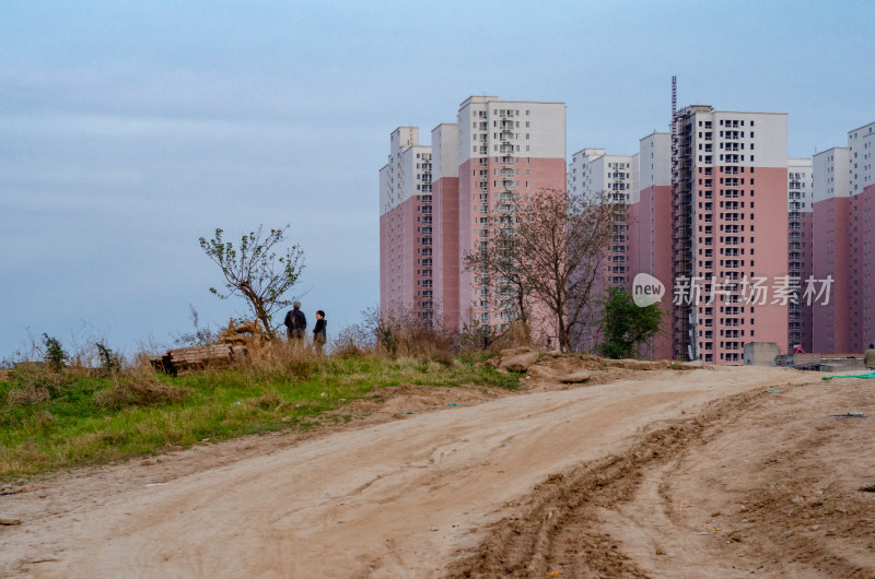 在城市郊外，土堆上拔地而起的高楼