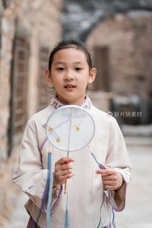 穿中国传统服饰走在古院落街道上的女孩