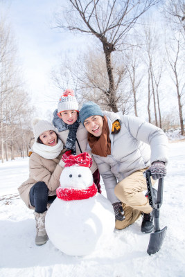 一家三口在雪地里堆雪人