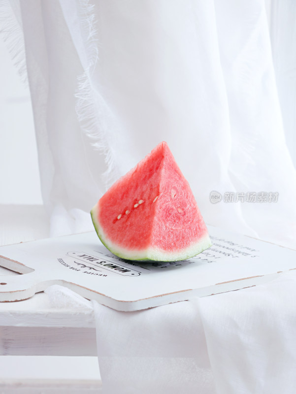 白色桌面上摆放着的切开的水果西瓜