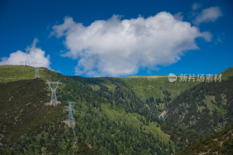 高耸入云的输电塔与青翠山峦