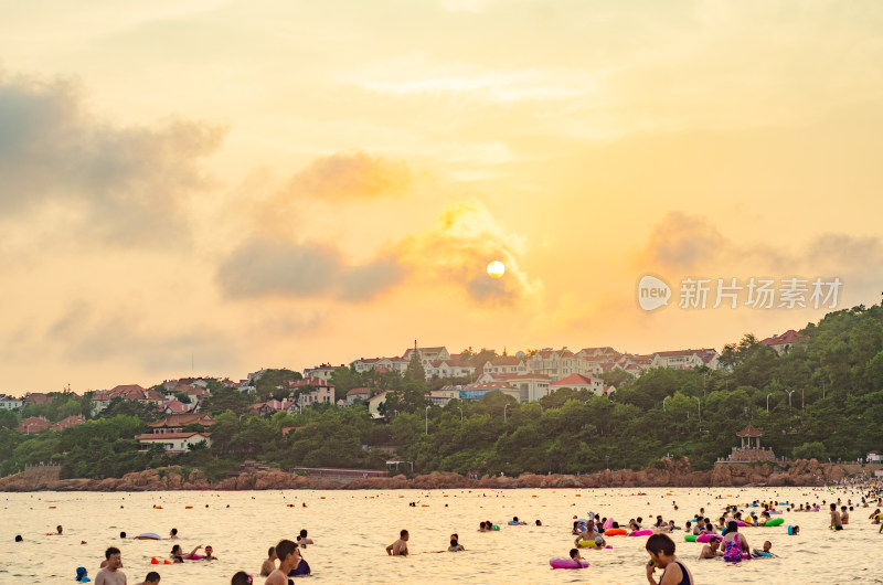 日落时分，青岛海水浴场许多游泳的人