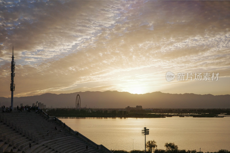 湖边观景台赏夕阳下的山脉和摩天轮