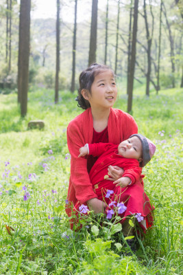 穿着红衣服抱着小妹妹的小姐姐 姐妹情