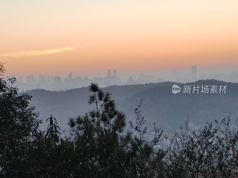 山林间遥望城市的日出景观