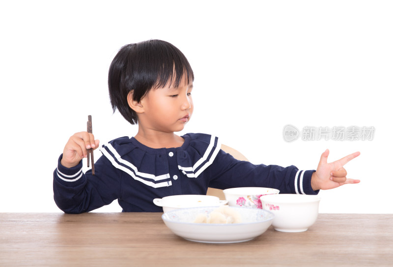 餐桌前即将吃饱而玩耍的中国小女孩