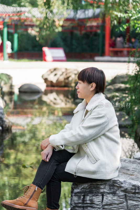 坐在公园湖边欣赏风景的中国女性
