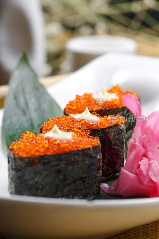 鹅颈瓷盘装的蟹子军舰手握寿司摆放在石头上