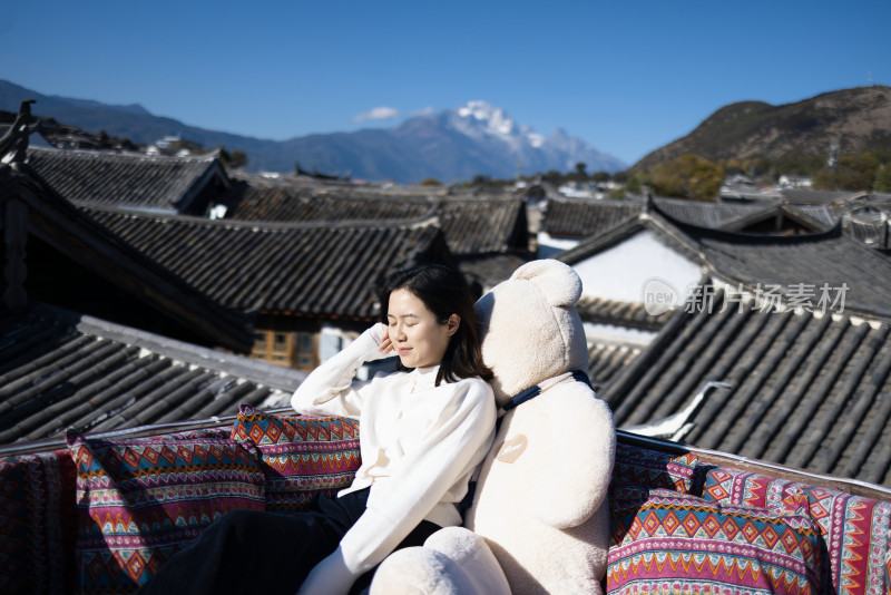 在丽江古城旅行的美女 背后是玉龙雪山