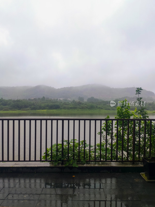 雨中湖畔围栏外的山景