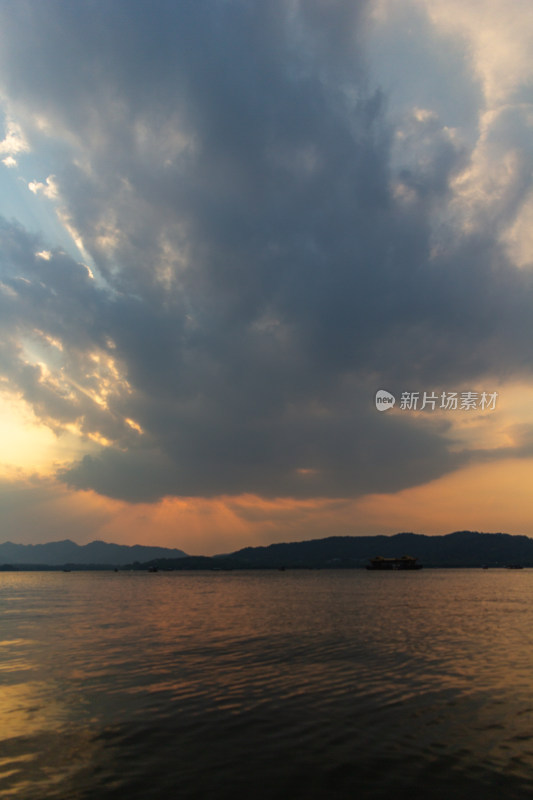 杭州西湖湖面夕阳下的山峦与云彩