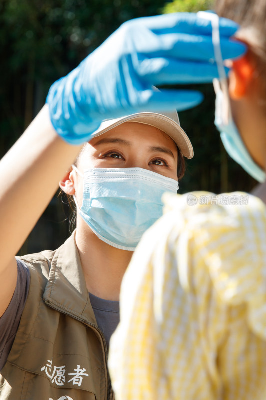 社区志愿者帮小女孩戴口罩