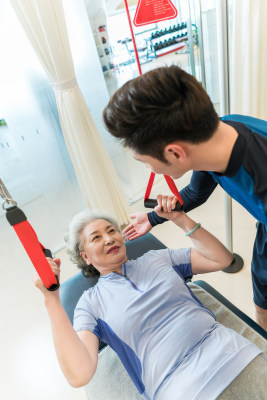 老年女子在私教的指导下健身