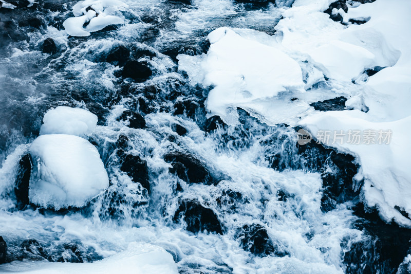 东北长白山冬季雪地上流动的河流