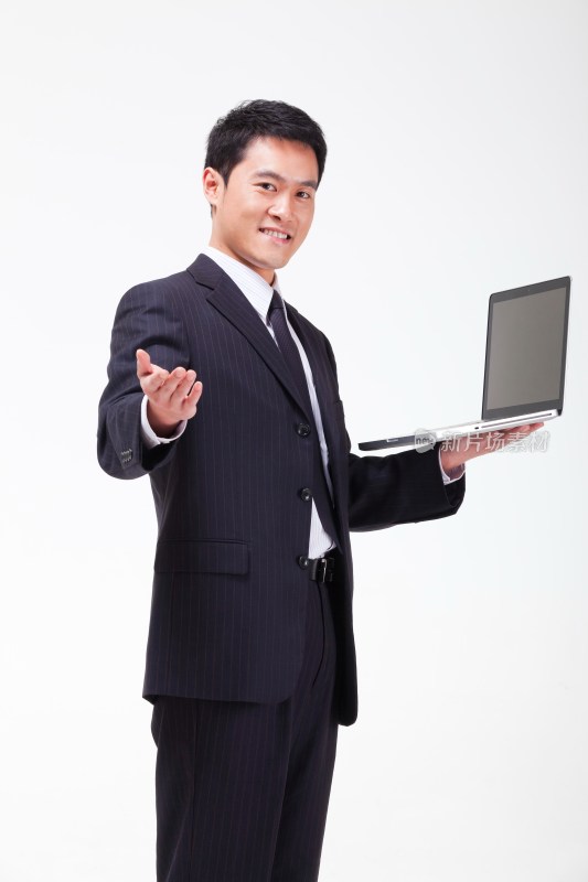 年轻的商务男士抱着笔记本电脑