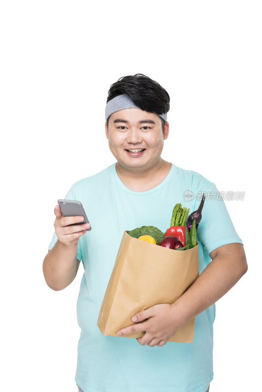 肥胖的年轻男子拿着各种蔬菜