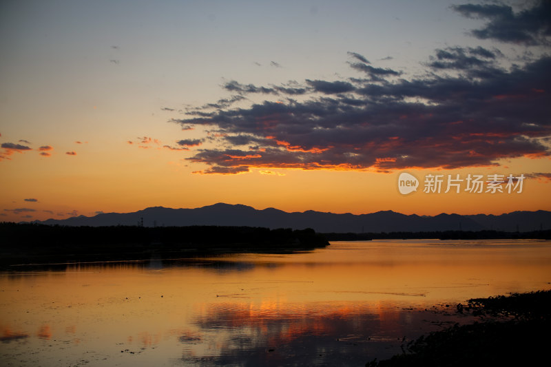 夕阳下水面上的鸟群晚霞