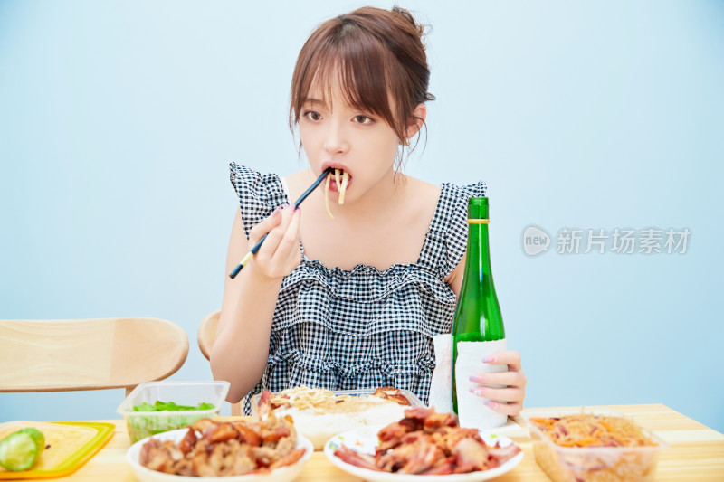 在餐桌前吃午餐喝白酒的亚洲少女