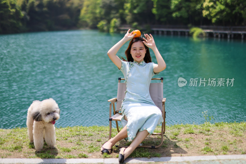 坐在湖边的美女和她的宠物
