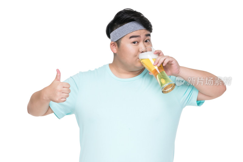 肥胖的年轻男子在喝啤酒