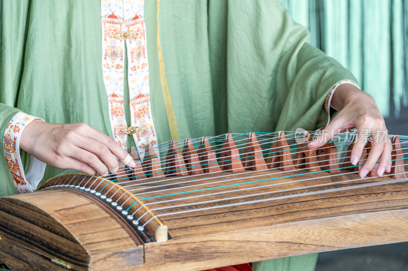 一位身穿中国传统汉服的女子弹奏古筝唯美