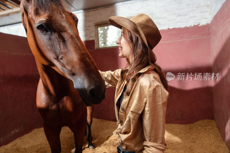 马厩里的快乐的青年女人和骏马