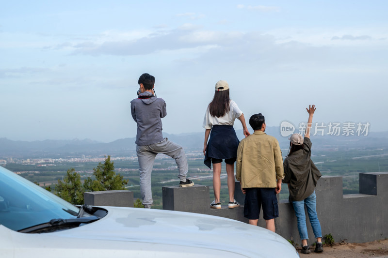 快乐的青年朋友站在山顶看风景