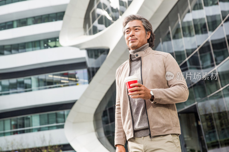 商务男士拿着咖啡杯去上班