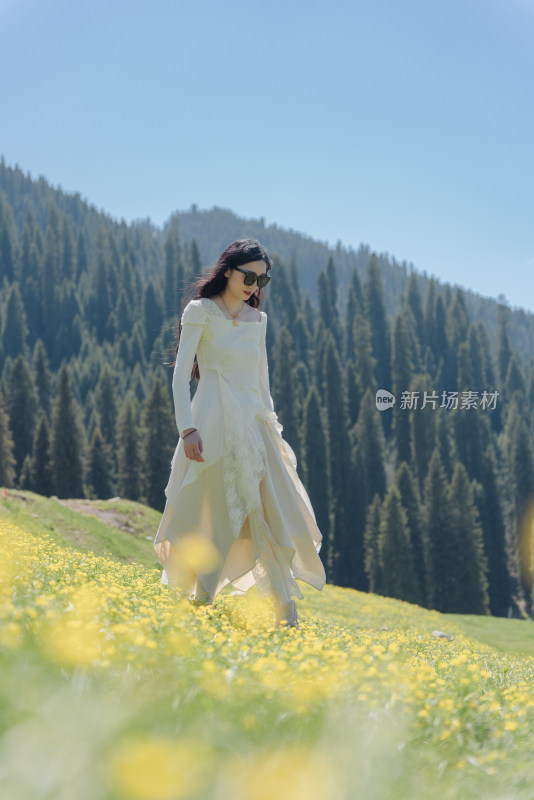 夏日新疆伊犁恰西草原女子漫步于山间花海