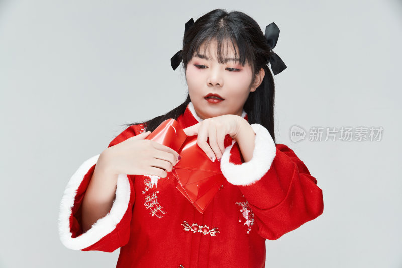 白色背景下身穿喜庆汉服手拿红包的可爱少女