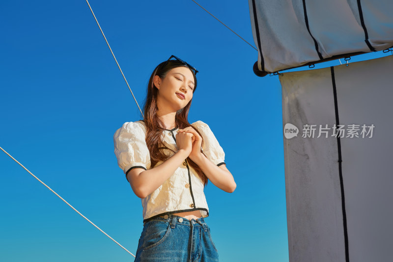 在湖畔木制帆船上的亚洲美女