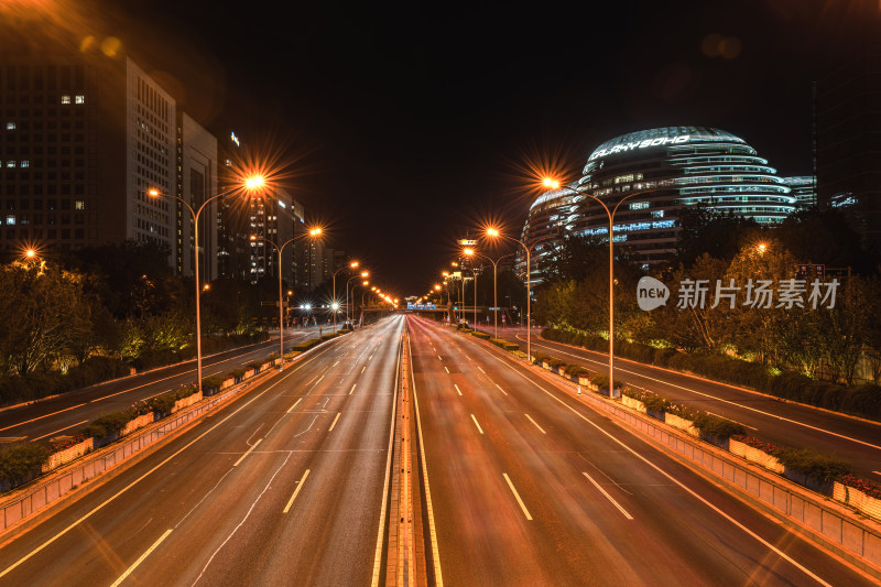 北京城市夜景下的宽阔道路车轨流光溢彩