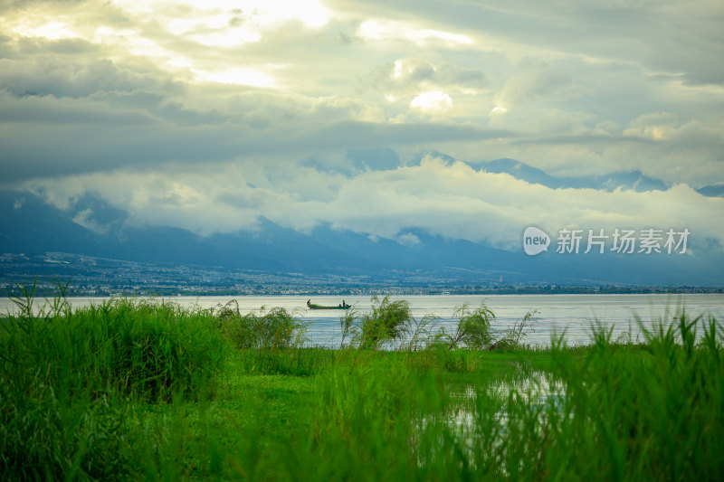 湖畔草地远山与小舟风景