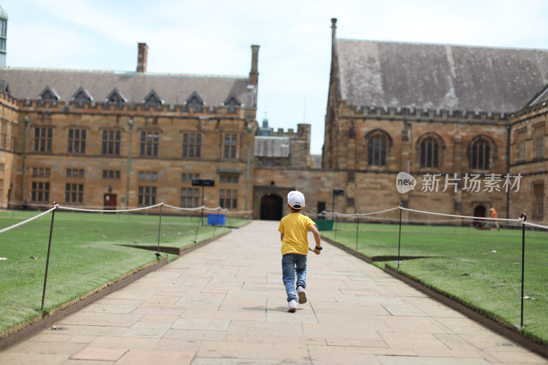 在澳大利亚悉尼大学步行道上奔跑的男孩