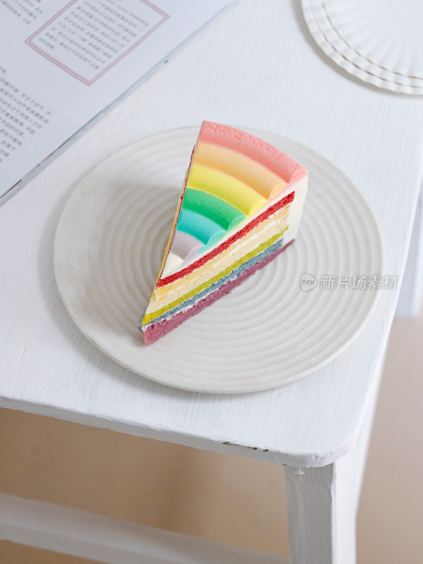 白色桌面碟子中的一块甜品彩虹蛋糕