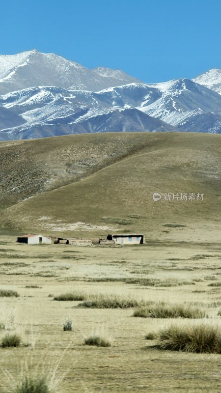 雪山下荒原中的小屋景象