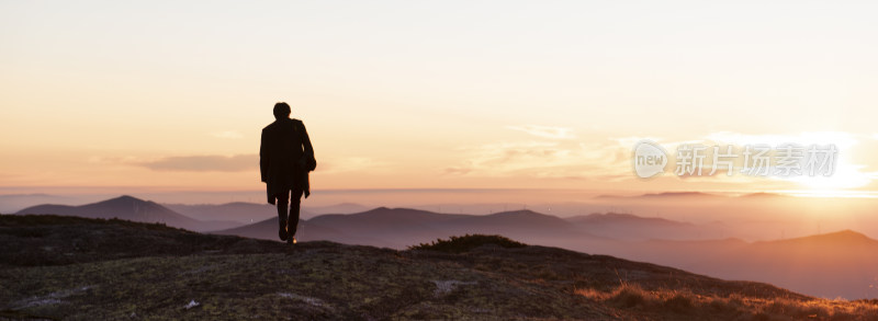 男子山顶逆光眺望远方