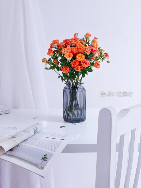 白色桌面上摆放着插好的鲜花玫瑰