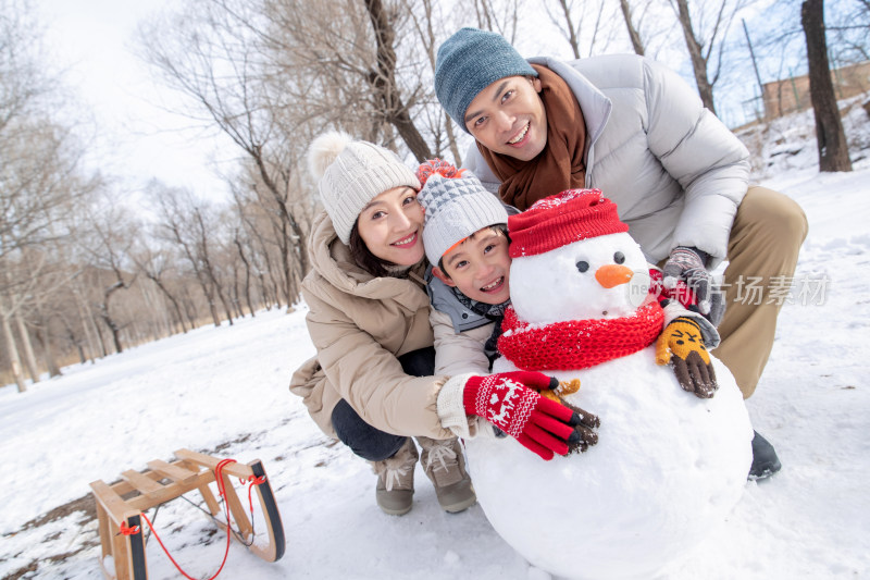 一家三口在雪地里堆雪人