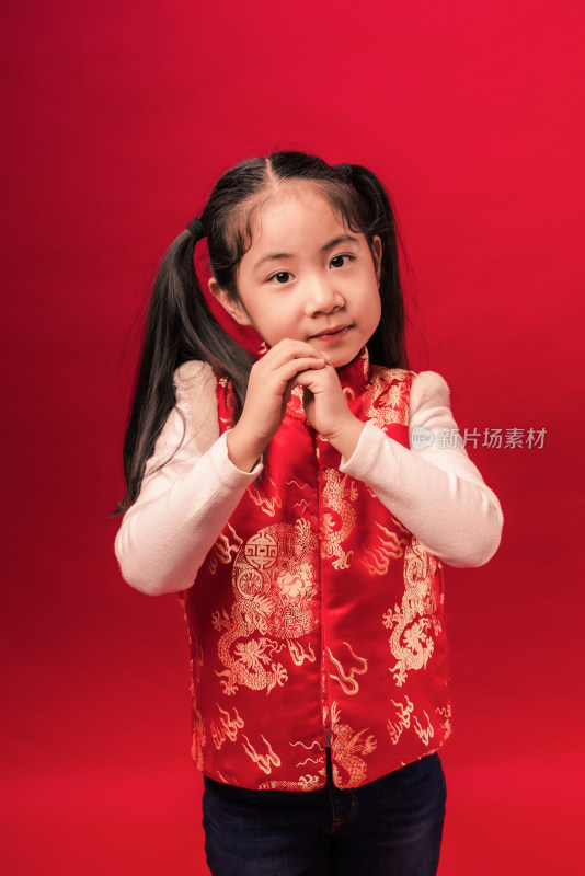 站在红色背景前作揖的中国女孩